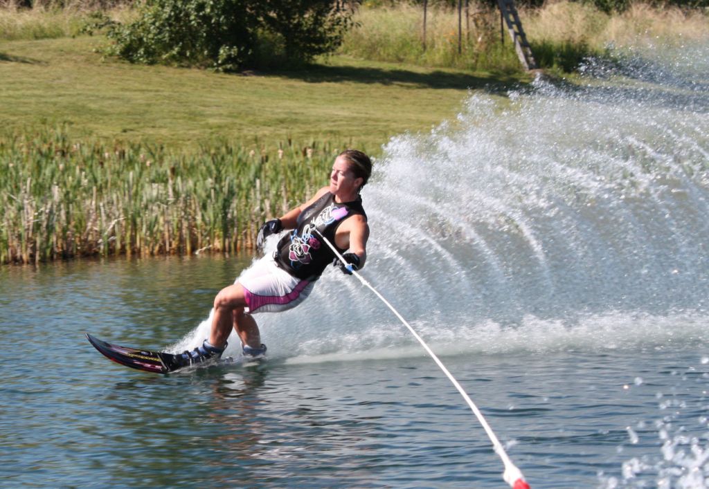 Kristy Kraus carving a slalom turn with a massive spray wall at Shalom Park